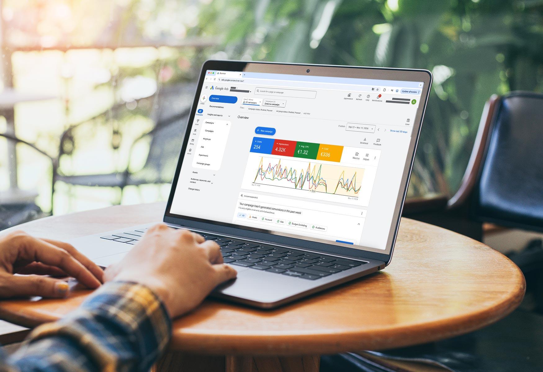Brandle - Google SEA dashboard Laptop op tafel met Google Ads dashboard zichtbaar, inclusief grafieken en campagneprestaties in een werkomgeving.